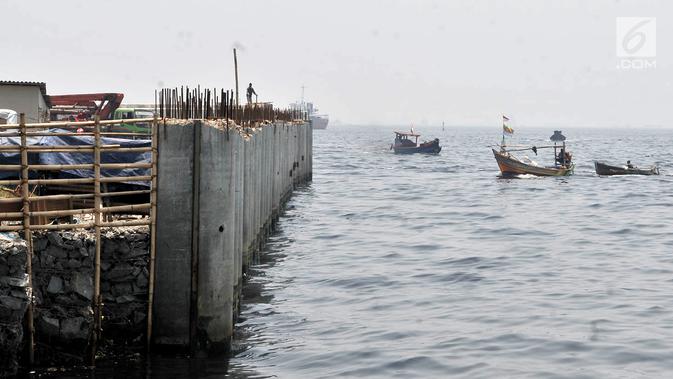 Perahu nelayan melintas di dekat proyek tanggul laut raksasa atau giant sea wall di Cilincing, Jakarta, Kamis (15/3). Tanggul laut raksasa ini diharapkan mampu mencegah rob yang kerap melanda pesisir Jakarta. (Merdeka.com/Iqbal Nugroho)