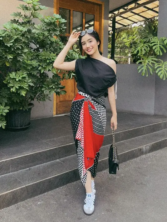 Febby Rastanty tampil mengenakan atasan one shoulder hitam yang dipadukan dengan kain sebagai bawahannya. [@febbyrastanty]
