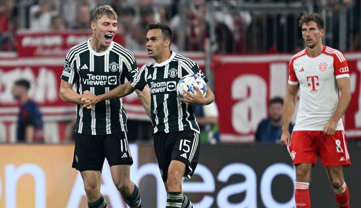 Pemain Manchester United, Sergio Reguilon (tengah) merayakan gol yang dicetak oleh Rasmus Hojlund (kiri) pada laga Grup A Liga Champions 2023/2024 melawan Bayern Munchen di Allianz Arena, Munchen, Jerman, 20 September 2023. (AFP/Christof Stache)