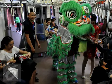  Barongsai memberikan hadiah kepada penumpang kereta api di stasiun Jakarta - Kota, Minggu (7/2). Menyambut Tahun Baru Imlek 2567, PT KAI Commuter Jabodetabek (KCJ) menghadirkan hiburan Barongsai bagi pengguna KRL. (Liputan6.com/JohanTallo)