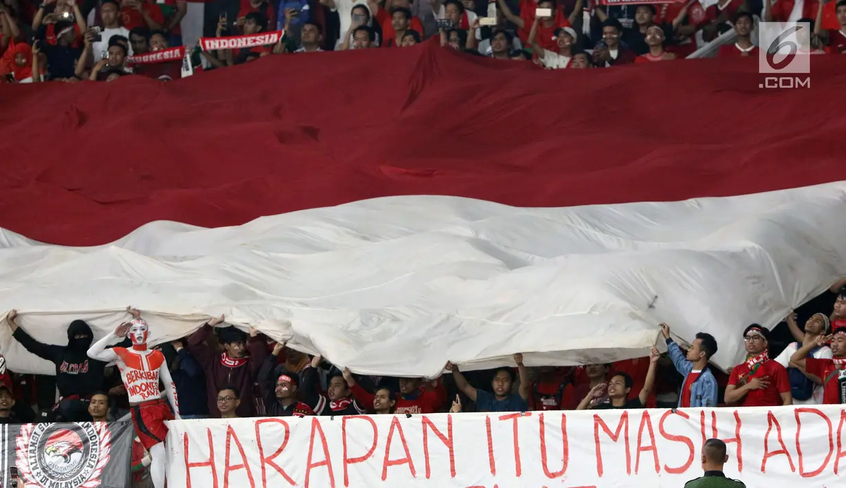 Suporter tim Garuda membentangkan bendera Merah Putih jelang menyaksikan laga Timnas Indonesia melawan Timor Leste pada penyisihan grup B Piala AFF 2018 di Stadion GBK, Jakarta, Selasa (13/11). Indonesia unggul 3-1. (Liputan6.com/Helmi Fithriansyah)