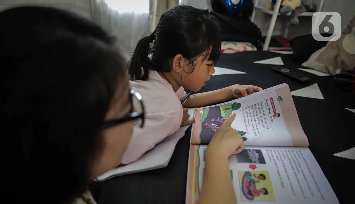 Seorang murid SD belajar di rumah bersama orang tuanya di kawasan Cinere, Jakarta, MInggu (5/4/2020). Gubernur DKI Jakarta Anies Baswedan memperpanjang kegiatan belajar dari rumah bagi pelajar di Jakarta hingga 19 April 2020. (Liputan6.com/Faizal Fanani)