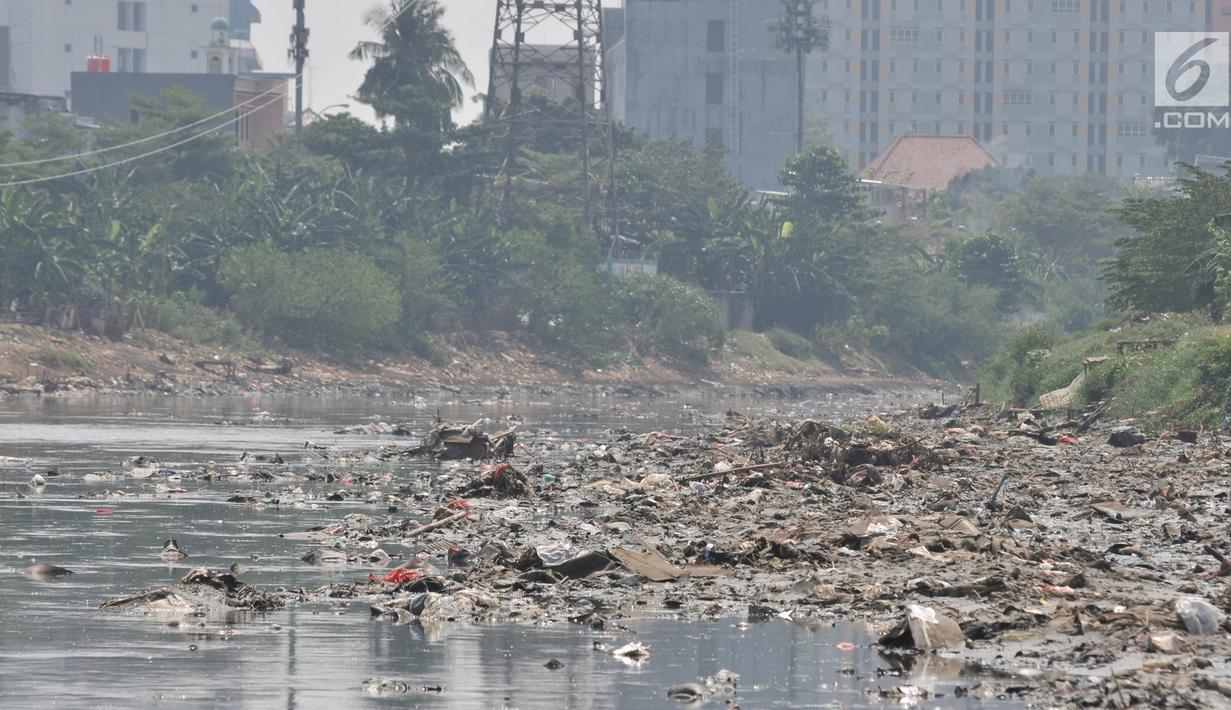Tumpukkan sampah yang muncul di permukaan Kanal Banjir Barat, Jakarta, Selasa (16/7/2019). Kemarau sejak dua bulan terakhir ini menyebabkan sampah-sampah yang mengendap di dasar sungai muncul ke permukaan sehingga menimbulkan bau tak sedap. (merdeka.com/Iqbal S Nugroho)