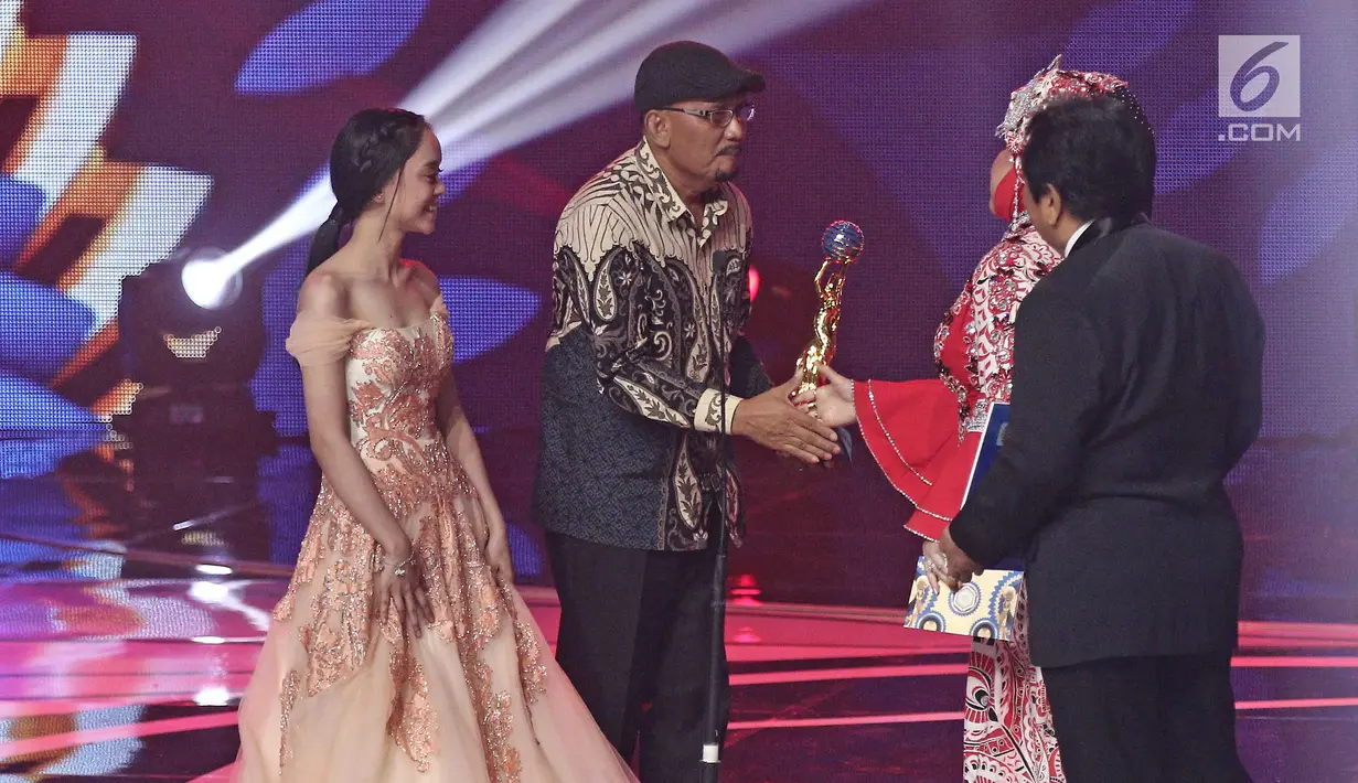 Pencipta lagu, Hendro Saki bersama penyanyi dangdut Lesti D'Academy saat menerima piala untuk kategori lagu dangdut terpopuler dalam ajang Indonesian Dangdut Awards 2017 di Studio 6 EMTEK CITY, Jakarta, Jumat (13/10). (Liputan6.com/Herman Zakharia)