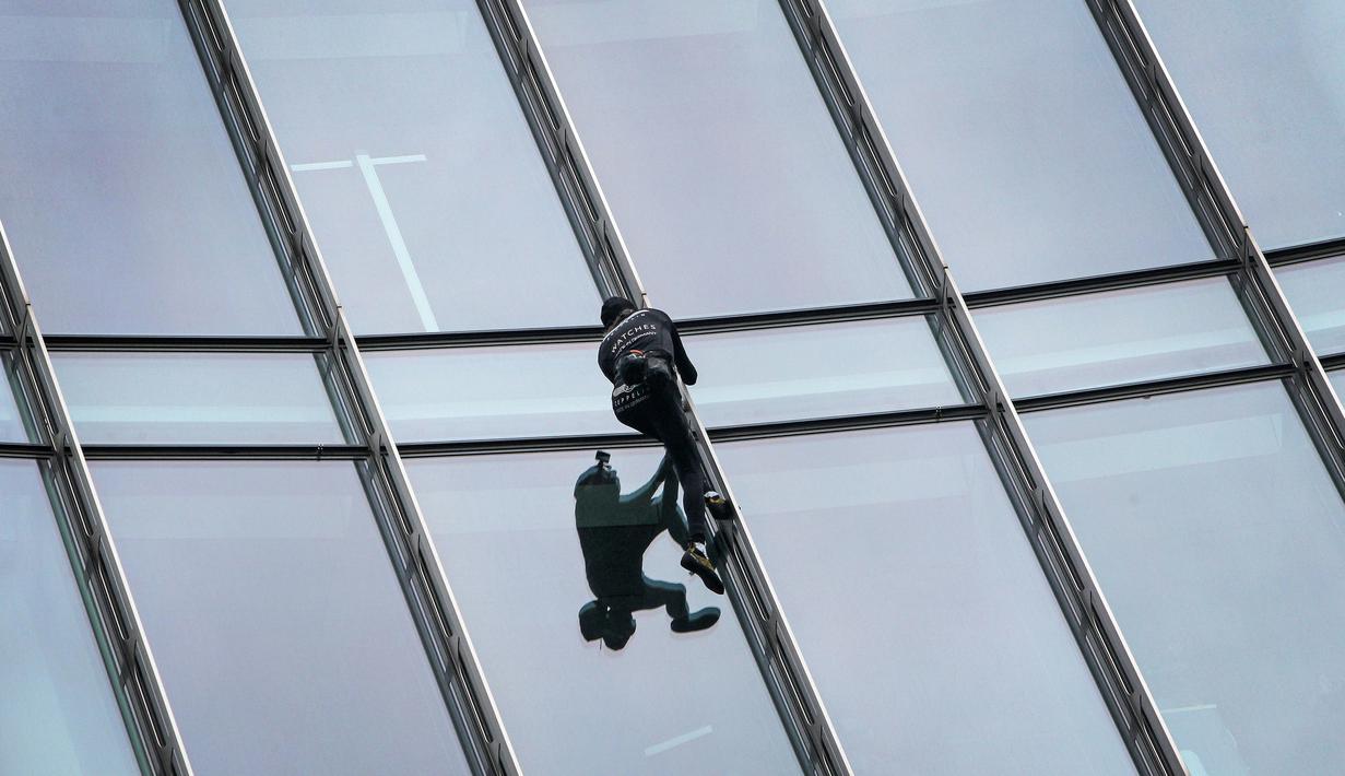 Pendaki kota Prancis, Alain Robert saat berusaha memanjat gedung XYZ di Frankfurt am Main, Sabtu (28/9/2019). Alain yang dikenal sebagai "The French Spiderman" kembali memanjat gedung tinggi di kota Jerman tersebut. (AFP Photo/Daniel Roland)