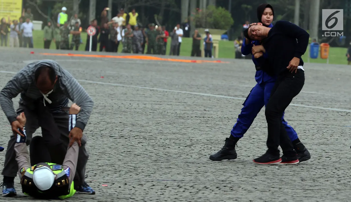 Prajurit Wanita Polri memamerkan aksi ilmu bela diri pada apel peringatan Hari Kartini 2018 di Lapangan Silang Monas, Jakarta, Rabu (25/4). Sebanyak 721 personel gabungan prajurit wanita TNI dan Polri melakukan atraksi. (Liputan6.com/Johan Tallo)