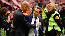Ernesto Valverde berbincang dengan pelatih Real Madrid, Zinedine Zidane sebelum pertandingan Real Madrid melawan Athletic Bilbao pada 18 Maret 2017. Valverde menggantikan posisi Luis Enrique, yang mundur di akhir musim. (AP Photo/Alvaro Barrientos, File)