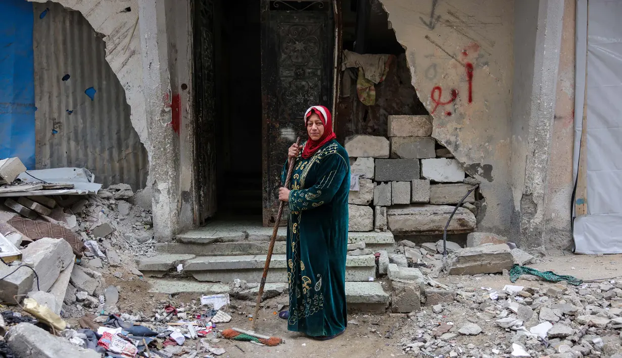 Shahira Sammour, 49 tahun, berpose di depan rumahnya yang hancur di Jabalia, Jalur Gaza utara, pada 9 Februari 2025. (Bashar TALEB/AFP)
