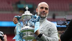 Manajer Manchester City, Pep Guardiola, berpose dengan trofi di lapangan setelah pertandingan final Piala FA Inggris antara Chelsea melawan Manchester City di Stadion Wembley, London, pada 16 Mei 2026. City memenangkan pertandingan dengan skor 1-0. Gelar FA Cup ketiga pada era kepelatihan Guardiola tersebut mengakhiri rentetan dua kekalahan beruntun City di partai final. (Adrian Dennis / AFP)