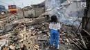 Seorang anak mencari sisa sisa barang paska kebakaran di permukiman kumuh di RW 02 Kampung Walang, Lodan Raya, Jakarta, Minggu (25/8). Kondisi Kampung Walang kini porak-poranda. (Liputan6.com/Faizal Fanani)