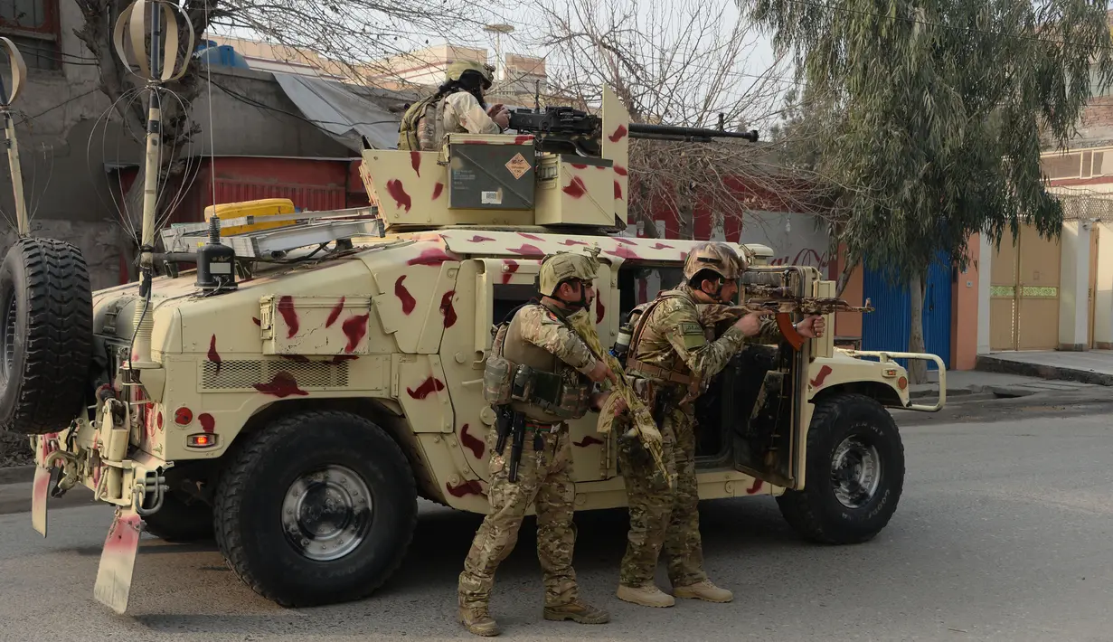 Tentara Afghanistan bersiap siaga di dekat sebuah kantor amal Inggris Save the Children saat terjadi serangan yang sedang berlangsung di Jalalabad, Afghanistan (24/1). Serangan tersebut sedikitnya melukai 11 orang. (AFP Photo/Noorullah Shirzada)
