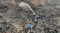 Pendinginan kebakaran lahan di perbatasan Kota Dumai dengan Kabupaten Bengkalis. (Liputan6.com/M Syukur)