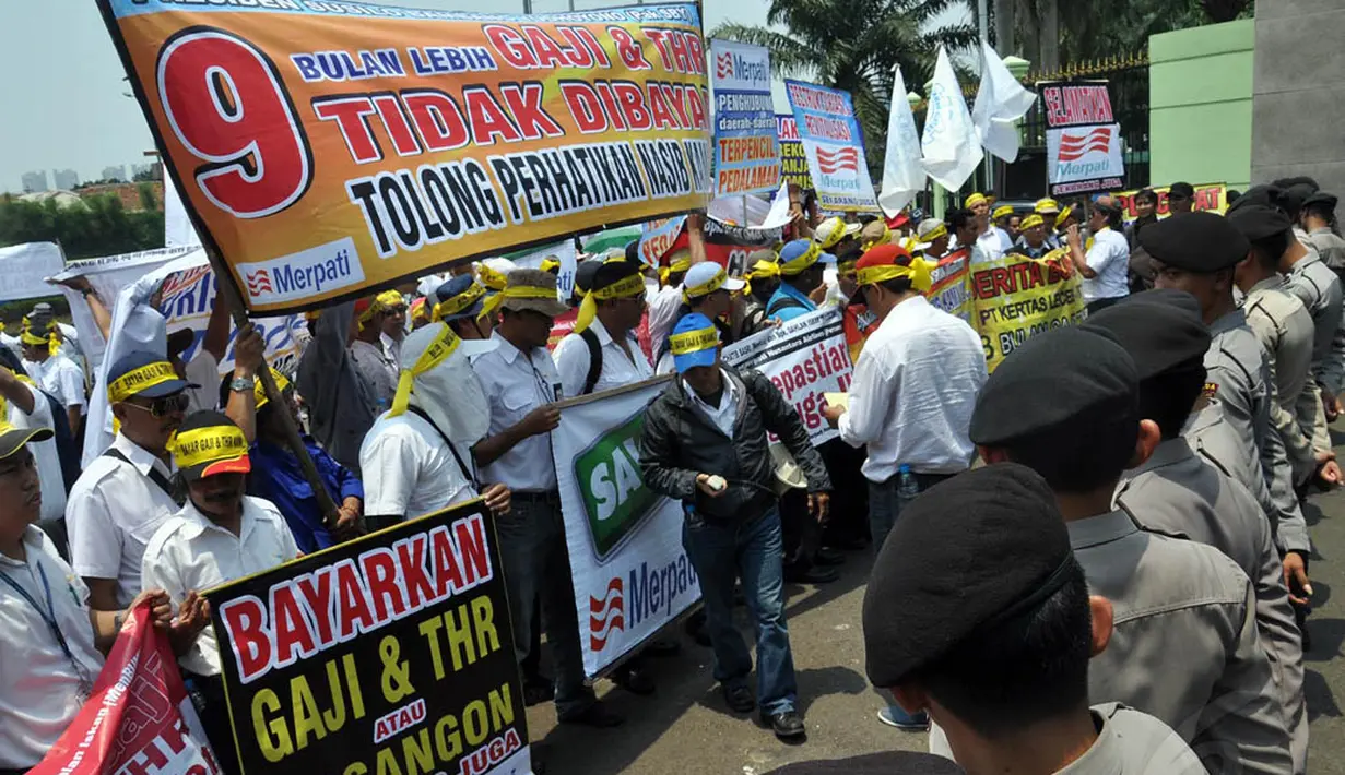 Karyawan Merpati melangsungkan demonstrasi damai sambil membawa poster dan memakai ikat kepala berwarna kuning berisi tentang tuntutan, Jakarta, (16/8/14). (Liputan6.com/Miftahul Hayat)