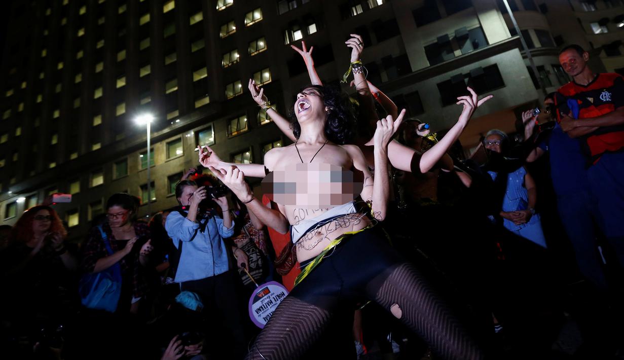 Sejumlah seniman wanita nekat bertelanjang dada saat menggelar demonstrasi di pusat kota Rio de Janeiro, Brasil, Rabu (1/6). Aksi dilakukan sebagai bentuk protes mereka terhadap maraknya kasus pemerkosaan dan kekerasan seksual. (REUTERS/Ricardo Moraes)