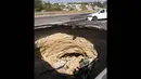 Penampakan lubang sinkhole raksasa yang tiba-tiba muncul di tengah jalan utama dekat Simferopol, ibukota Crimea. (REUTERS/Pavel Rebrov)