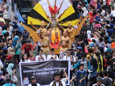 Peserta pawai perayaan Hari Batik Nasional berusaha menembus kerumunan warga saat Hari Bebas Kendaraan di kawasan Bundaran HI, Jakarta, Minggu (1/10). Parade Batik Nusantara ini perayaan Hari Batik Nasional 2 Oktober. (Liputan6.com/Helmi Fithriansyah)