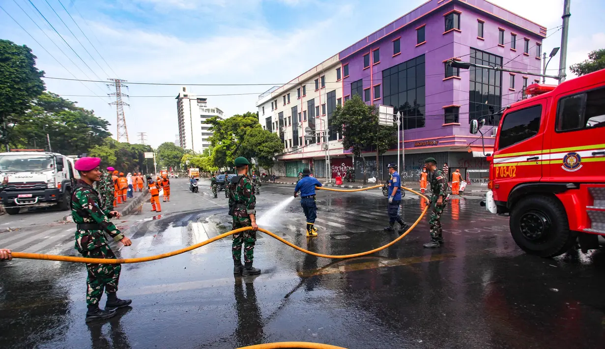 Hingga Minggu (31/8/2025), sejumlah petugas berseragam oranye bersama personel TNI mulai menyapu jalan dan mengumpulkan sampah yang berserakan. (merdeka.com/Arie Basuki)