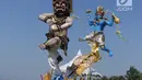Peserta mengarak ogoh-ogoh dalam Festival Ogoh-Ogoh di Pantai Lagoon Ancol, Jakarta, Minggu (18/3). Terdapat 6 ogoh-ogoh yang dihadirkan dalam festival ini. (Liputan6.com/Arya Manggala)