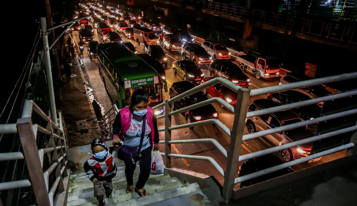 Warga menaiki JPO di tengah kepadatan lalu lintas di Manila, Filipina (3/8/2020). Kemacetan terjadi ketika orang-orang bergegas keluar dari Metro Manila beberapa jam sebelum pemerintah memberlakukan lockdown di kawasan itu akibat lonjakan kasus penyakit Covid-19. (Xinhua/Rouelle Umali)