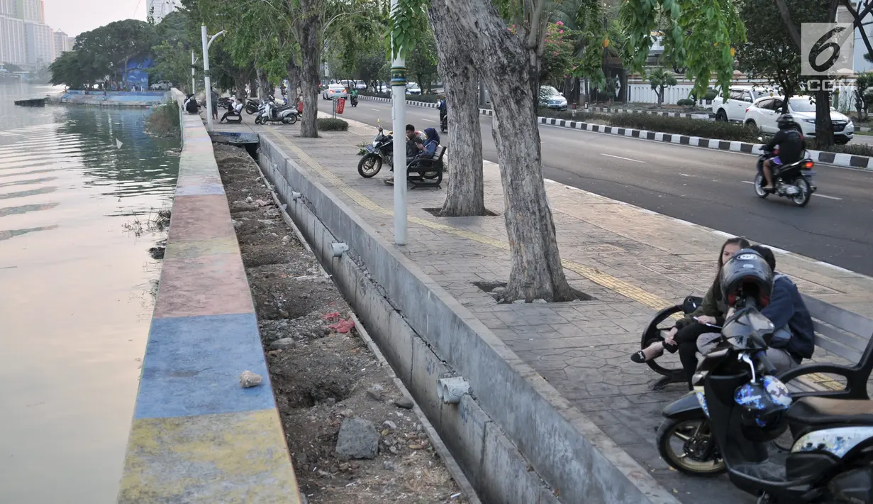 Warga memarkirkan sepeda motor di trotoar Danau Sunter, Jakarta, Senin (22/7/2019). Tidak adanya fasilitas parkir di kawasan tersebut menyebabkan pengunjung Danau Sunter memarkirkan sepeda motor mereka di sepanjang trotoar sehingga mengganggu akses pejalan kaki. (merdeka.com/Iqbal Nugroho)