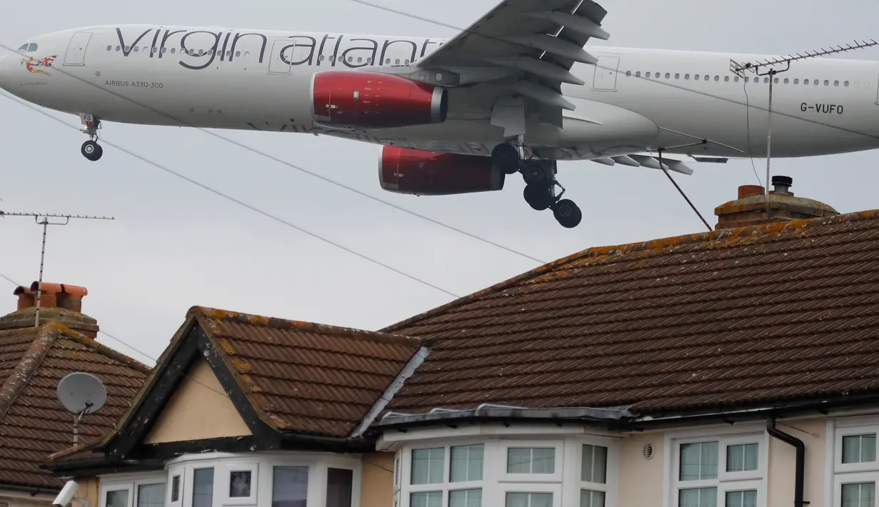 Pesawat Virgin Atlantic terbang rendah dekat atap rumah saat bersiap mendarat di Bandara Heathrow, London, 25 Oktober 2016. Perumahan yang terletak di Myrtle Avenue itu hanya sekitar 91 meter dari landasan Bandara Heathrow. (AP Photo / Frank Augstein)