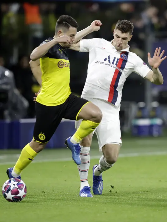Bek Dortmund, Raphael Guerreiro berebut bola dengan bek PSG, Thomas Meunier pada pertandingan leg pertama babak 16 Liga Champions di Dortmund, Jerman (18/2/2020). Dortmund menang 2-0 atas PSG. (AP Photo/Michael Probst)