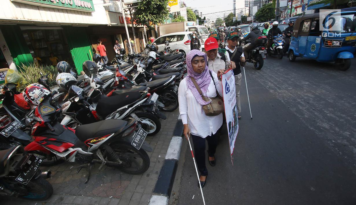 Penyandang disabilitas melintas di samping trotoar saat kampanye Bulan Patuh Pedestrian di Jalan Sabang, Jakarta, Rabu (30/8). Kampanye dilakukan untuk memantau fasilitas akses pejalan kaki untuk disabilitas. (Liputan6.com/Immanuel Antonius)