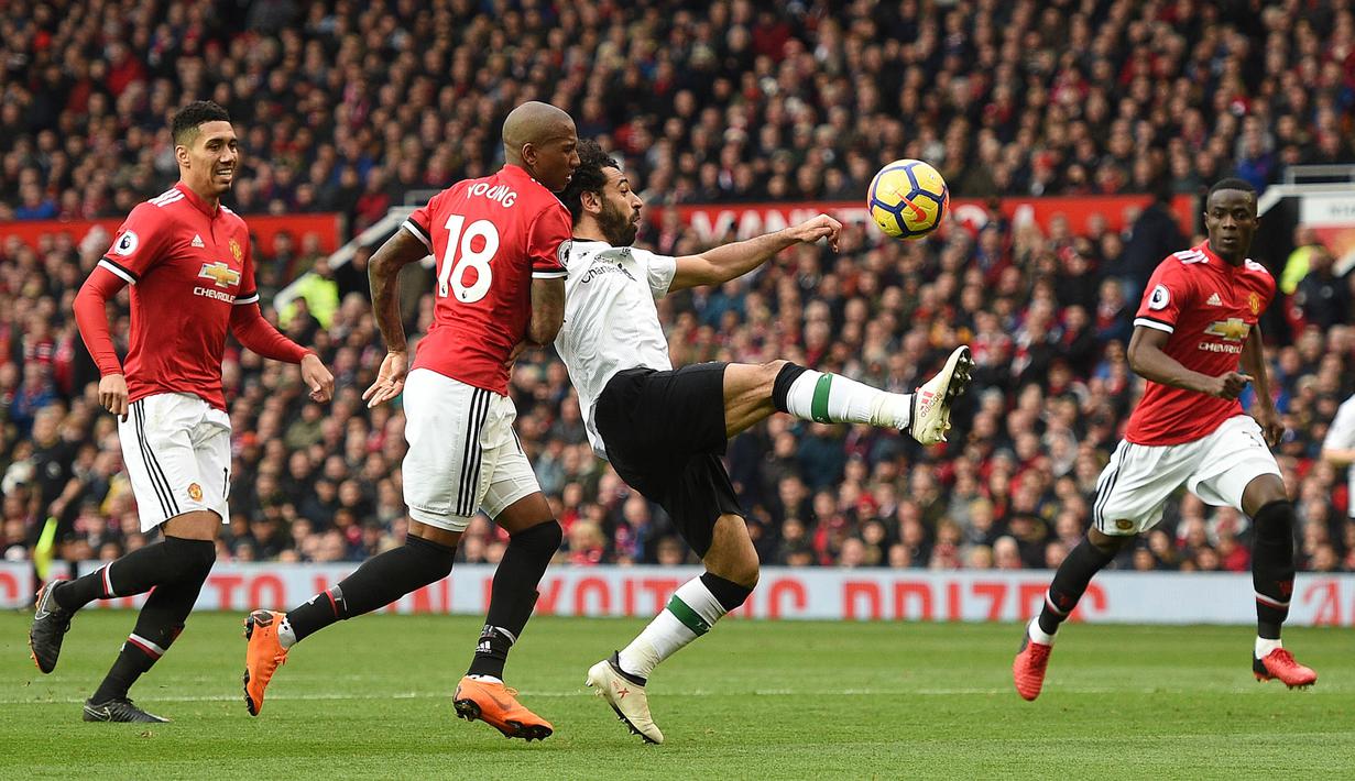 Gelandang Liverpool, Mohamed Salah berebut bola dengan gelandang Manchester United, Ashley Young pada laga Premier League di Stadion Old Trafford, Manchester, Sabtu (10/3/2018). MU menang 2-1 atas Liverpool. (AFP/Oli Scarff)