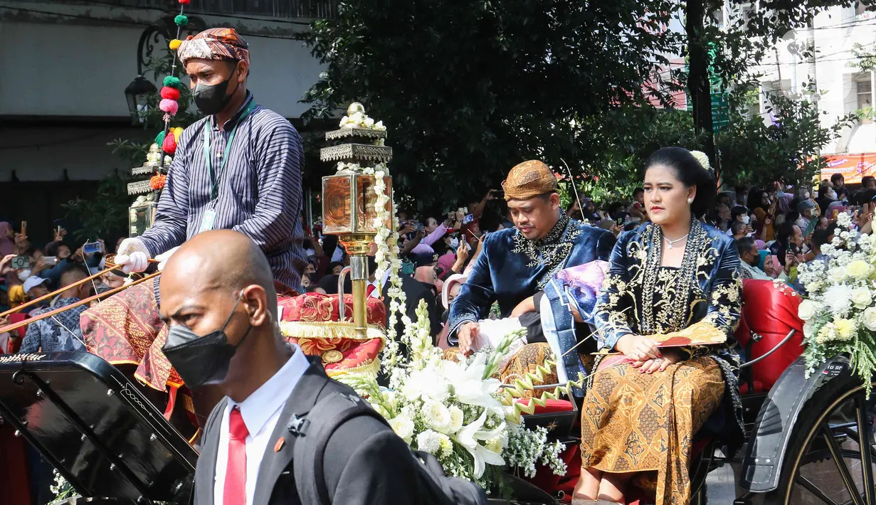 Kahiyang Ayu didampingi sang suami Bobby Nasution saat menaiki kereta dalam mengikuti prosesi kirab Ngunduh Mantu di kawasan Selamet Riyadi, Solo, Jawa Tengah, Minggu (11/12/2022). Kirab ngunduh mantu pernikahan putra bungsu Presiden Joko Widodo, Kaesang Pangarep dan istrinya Erina Gudono yang dimulai dari Loji Gandrung menuju Pura Mangkunegaran tersebut disaksikan ribuan masyarakat Solo dan sekitarnya. (Liputan6.com/Herman Zakharia)