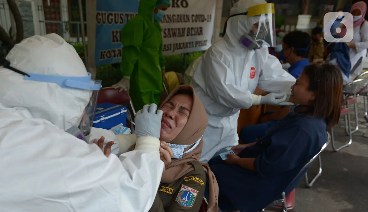 Petugas medis mengambil sampel lendir saat tes usap (swab test) pegawai kecamatan Sawah Besar, Jakarta, Selasa (18/8/2020). Tes swab yang dilakukan terhadap seluruh pegawai kecamatan Sawah Besar itu sebagai upaya memutus mata rantai penyebaran Virus Corona Covid-19. (merdeka.com/Imam Buhori)
