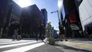 Orang-orang yang mengenakan masker pelindung untuk membantu mengekang penyebaran COVID-19 menyeberangi jalan di Tokyo, Jepang, Kamis, (4/2/2021). Tokyo mengonfirmasi lebih dari 730 kasus baru COVID-19 pada 4 Februari 2021. (AP Photo/Eugene Hoshiko)