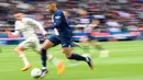 Pemain Paris Saint-Germain, Kylian Mbappe menggiring bola untuk melewati pemain FC Lorient pada laga lanjutan Liga Prancis 2022/2023 di The Parc des Princes Stadium, Paris, Prancis. 30 April 2023. (AFP/Franck Fife)