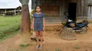 Seorang gadis berpose di samping bom yang dijatuhkan oleh pesawat AS di pintu masuk rumahnya di Desa Ban Napia, Provinsi Xieng Khouang, Laos (03/9). Sekitar 30 persen bom yang dijatuhkan gagal meledak, termasuk bom klaster.(REUTERS/Jorge Silva)