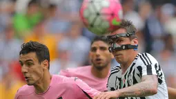 Striker Juventus, Mario Mandzukic, duel udara dengan pemain Palermo pada laga Serie A di Stadion Juventus, Turin, Minggu (17/4/2016). Kemenangan ini membuat Juve kian kokoh di puncak klasemen. (AFP/Marco Bertorello)