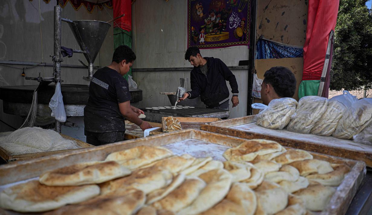 Seorang pembuat roti Mesir membuat Qatayef, pancake tradisional yang dibuat selama bulan puasa suci Ramadan, di tokonya, Kairo, Mesir, pada Kamis 12 Maret 2026. (Khaled DESOUKI/AFP)