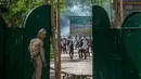 Sejumlah mahasiswa Kashmir melempar batu ke polisi India yang berdiri di gerbang sebuah perguruan tinggi di Srinagar, Kashmir yang dikuasai India, (23/5). (AP Photo/Dar Yasin)