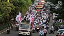 Relawan capres dan cawapres nomor urut 01 Joko Widodo atau Jokowi dan Ma'ruf Amin menggelar konvoi menuju lokasi debat Pilpres 2019 di Jakarta, Minggu (17/2). Massa berkonvoi menggunakan sepeda motor, bus, dan truk. (Liputan6.com/JohanTallo)