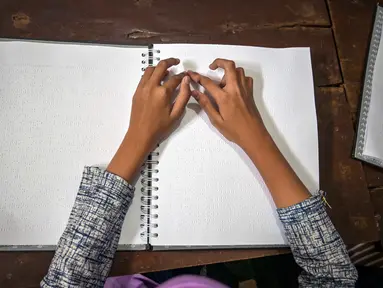 Seorang siswa tunanetra membaca Al-Quran dalam huruf Braille selama bulan suci Ramadan 1447 Hijriah di sebuah sekolah di Surabaya, Jawa Timur, pada 27 Februari 2026. (JUNI KRISWANTO/AFP)