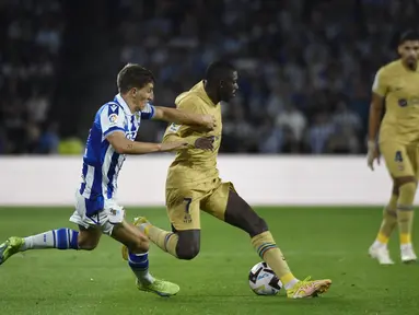 Bek Real Sociedad Aihen Munoz (kiri) menantang pemain depan Barcelona Ousmane Dembele dalam lanjutan LaLiga 2022/2023 di Reale Seguros Stadium, San Sebastian, Sein (22/8/2022) dini hari WIB. Barcelona mempermalukan tuan rumah Real Sociedad 4-1 berkat dua gol penyerang anyar Robert Lewandowski. (Photo by Ander GILLENEA / AFP)