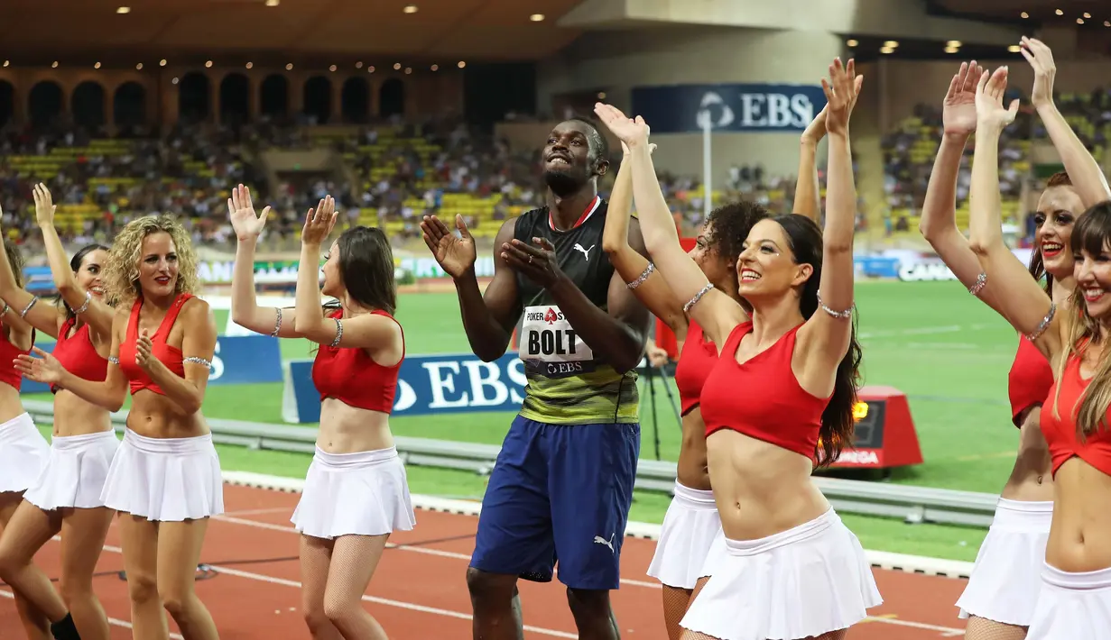 Pelari Usain Bolt melakukan selebrasi menari bersama wanita-wanita cantik di Stadium Louis II, Monaco, (21/7). Usain Bolt asal Jamaika menjuarai kejuaaran atletik lari 100m Diamond League. (AFP Photo/Yann Coatsaliou)