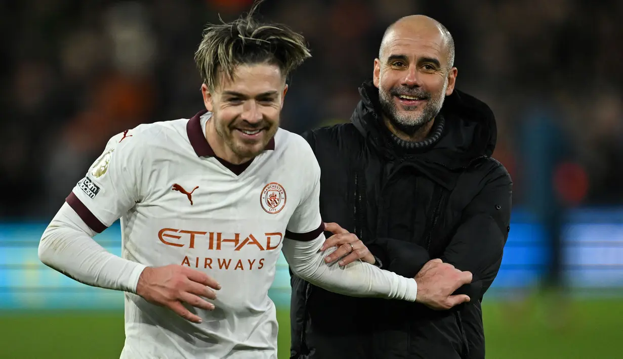 Selebrasi kemenangan gelandang Manchester City, Jack Grealish bersama pelatih Pep Guardiola setelah mengalahkan Luton Town 2-1 pada laga pekan ke-16 Liga Inggris 2023/2024 di Kenilworth Road, Luton, Minggu (10/12/2023) malam WIB. (AFP/Justin Tallis)