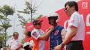 Pembalap MotoGP Marc Marquez secara simbolik memakaikan helm dan jaket kepada perwakilan siswa SMK saat acara kampanye keselamatan berkendara di BSD, Tangerang Selatan (10/17). (Liputan6.com/Pool/Bon)