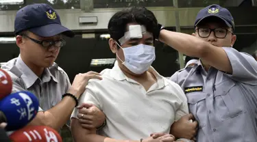 Seorang pria saat dibekuk aparat kepolisian di Taipei, Taiwan, Jumat (18/8). Pria yang diidentifikasi bernama Lu tersebut berusaha masuk Istana Kepresidenan Taiwan dengan membawa pedang Samurai. (AFP Photo/Sam Yeh)