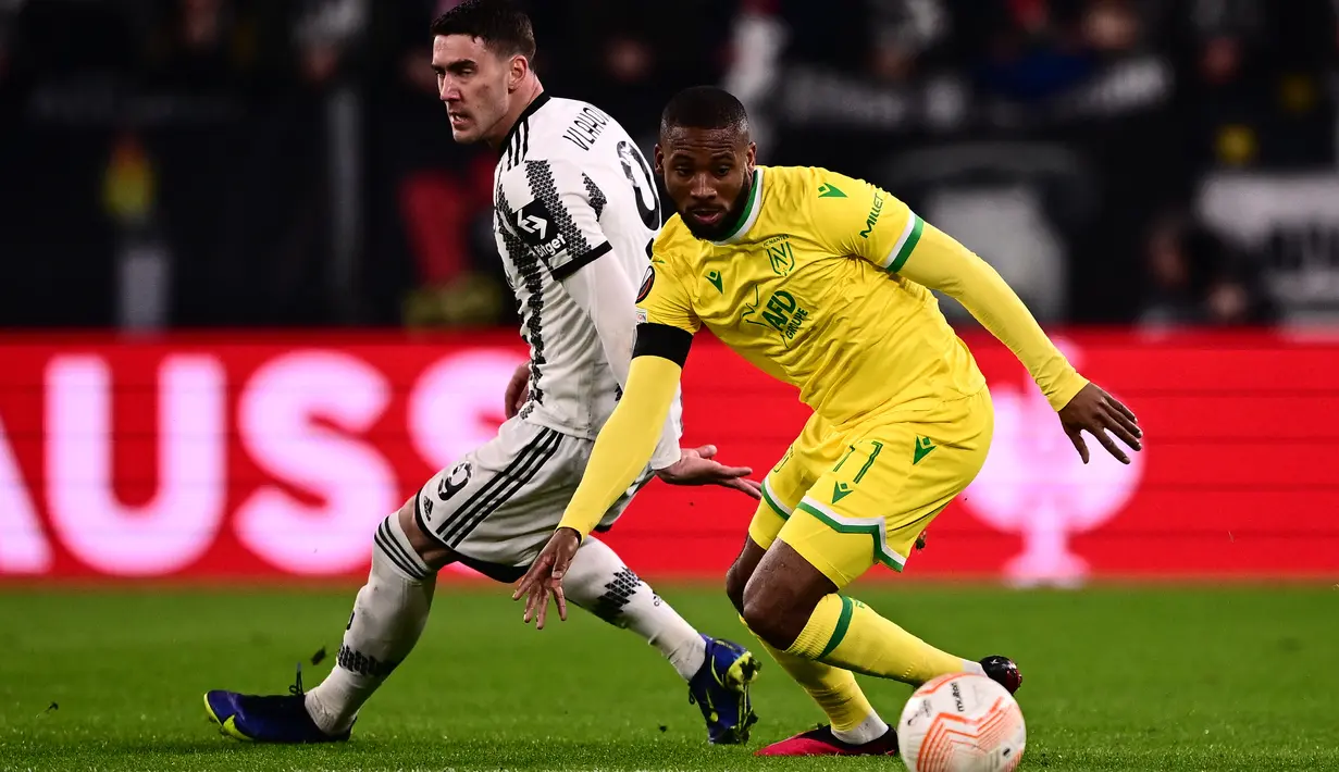 Penyerang Nantes Marcus Coco (kanan) mengontrol bola di sekitar penyerang Juventus Dusan Vlahovic dalam duel leg pertama play-off babak gugur Liga Europa 2022/2023 di Allianz Stadium, Jumat (17/2/2023) dini hari WIB. Juventus dominan di setiap aspek di lapangan, tapi Nantes melawan dengan pendekatan serangan balik cepat. (Marco BERTORELLO / AFP)