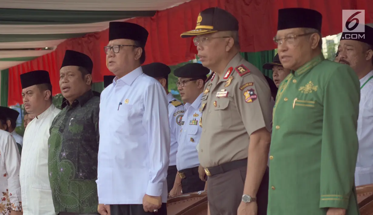 Menteri Dalam Negeri Tjahjo Kumolo, Ketua PBNU Said Aqil Siradj, menyanyikan lagu Indonesia Raya pada Apel Hari Santri Nasional 2017, di Tugu Proklamasi, Jakarta, Minggu (22/10). (Liputan6.com/Fery Pradolo)