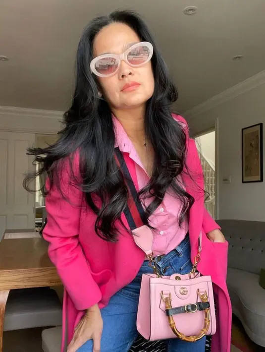Tampil bak cewek kue, gaya Donna satu ini dengan kemeja pink muda, blazer fuschia, celana jeans, dan hand bag warna senada juga tak kalah menarik. (Instagram/donnaharunofficial).
