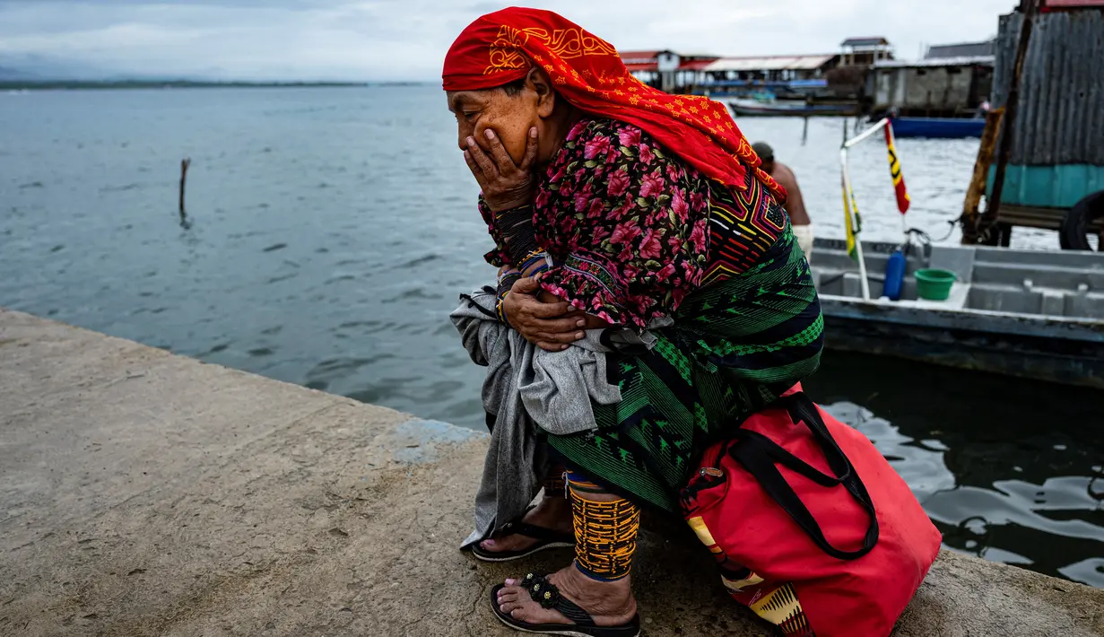 Seorang perempuan Penduduk Asli Guna menunggu di dermaga untuk pemindahannya dari pulau Carti Sugtupu ke daratan, di Guna Yala Comarca, di pantai Karibia di Panama, pada 03 Juni 2024. (MARTIN BERNETTI / AFP)