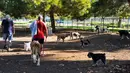 Pemilik anjing tiba pada pagi hari untuk mencoba mengatasi panas di Sepulveda Basin Dog Park di Los Angeles pada Rabu, (31/8/2022). Gelombang panas ini diperkirakan akan menyebar ke California Utara di akhir minggu. (AP Photo/Richard Vogel)