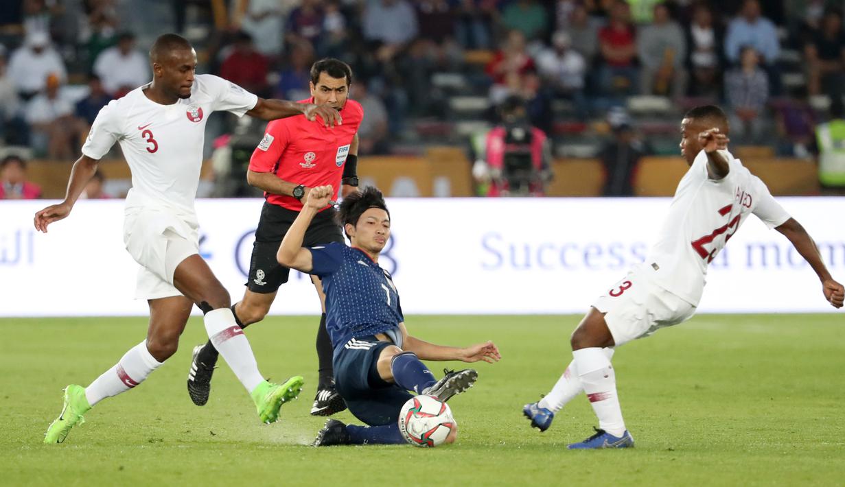 Bek Qatar, Assim Madibo, berebut bola dengan gelandang Jepang, Gaku Shibasaki, pada laga final Piala Asia 2019 di Stadion Zayed Sports City, Abu Dhabi, Jumat (1/2). Qatar menang 3-1 atas Jepang. (AFP/Karim Sahib)