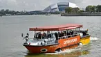 Sebuah wahana amfibi yang membawa turis melewati Stadion Nasional di Singapura pada 19 Februari 2019. Mobil-perahu mirip bebek ini mengantarkan pelancong berpetualang seru melihat keindahan Negeri Singa melalui jalur darat dan sungai. (Roslan RAHMAN/AFP)